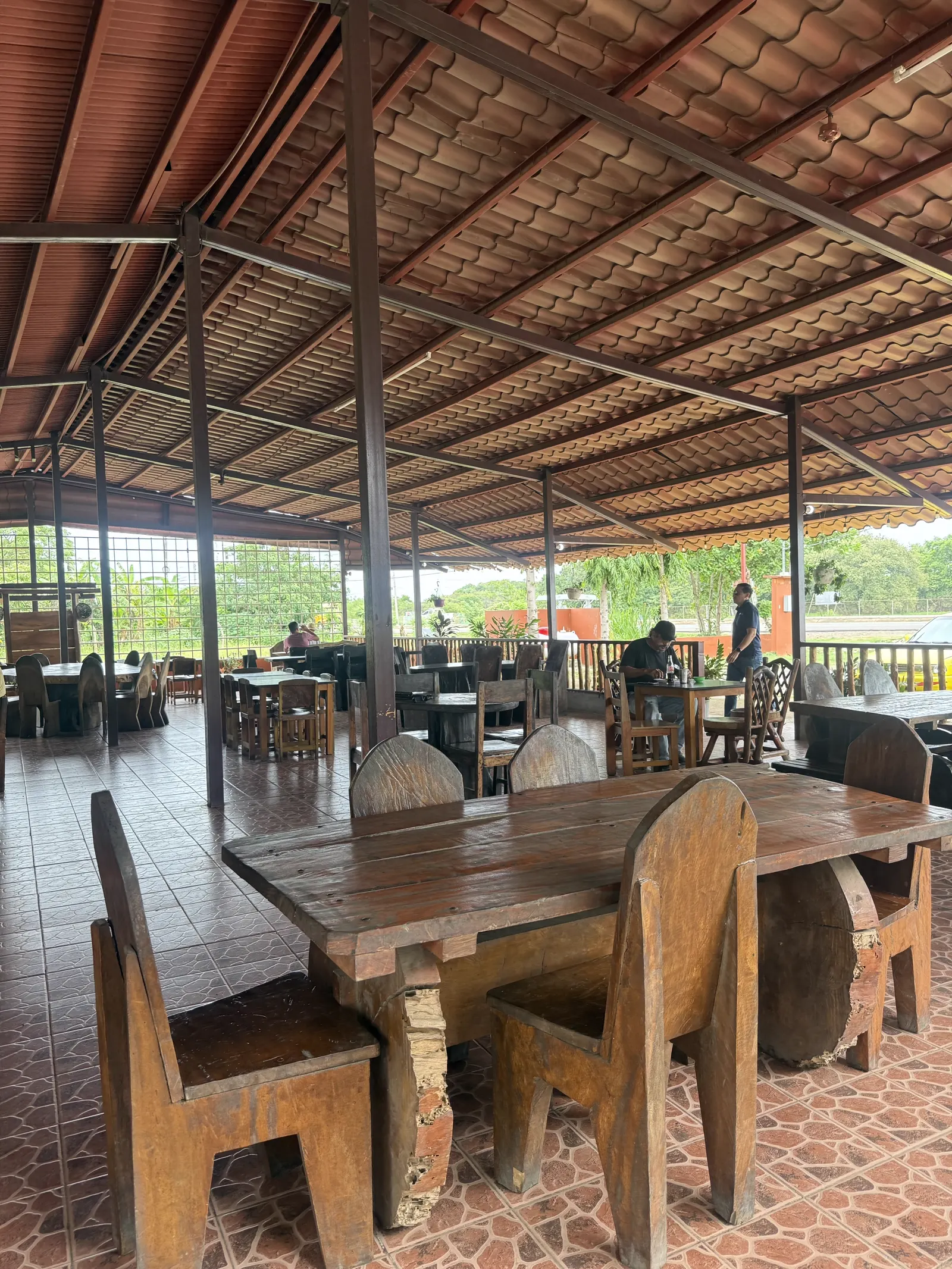 Mesas y sillas de madera con canto natural en el comedor abierto