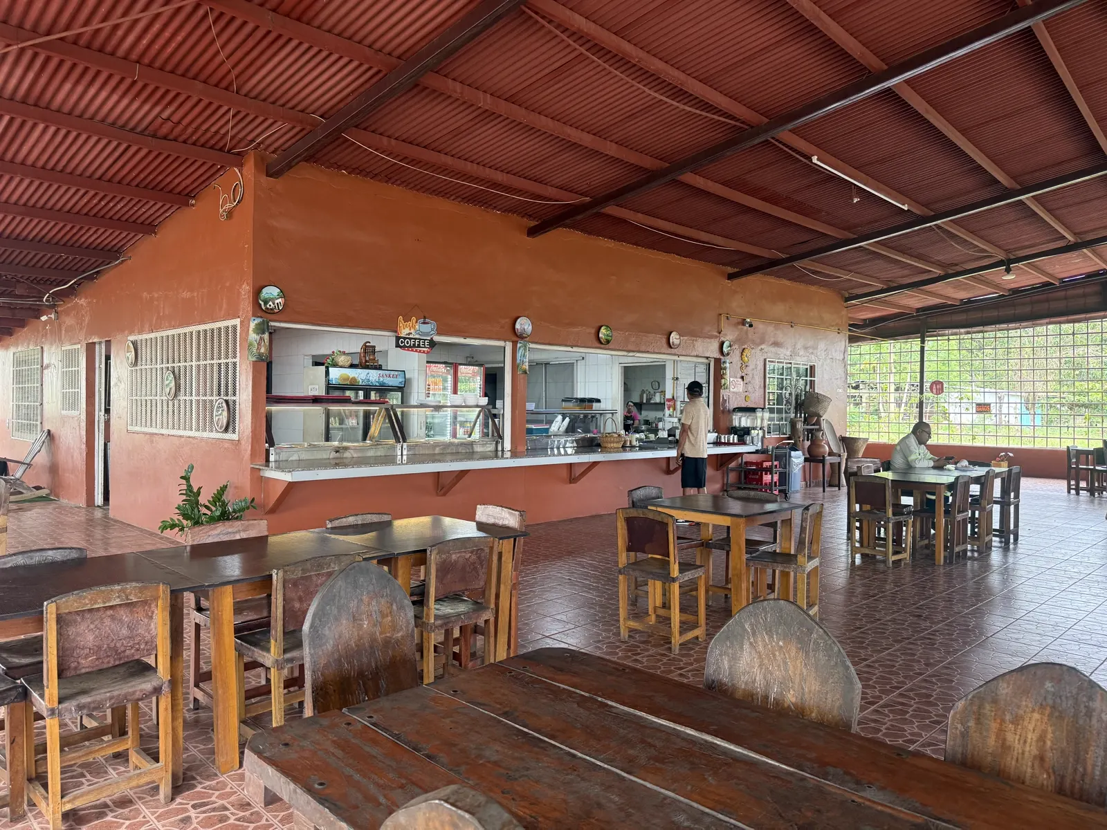 Vista general del comedor con la barra de despacho y mesas de madera